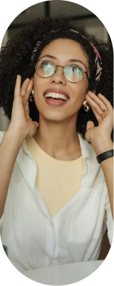Mulher de óculos sorrindo e com as mãos no fone